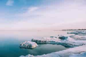 Free photo high angle shot of the frozen shore of the sea in winter under the calm sky