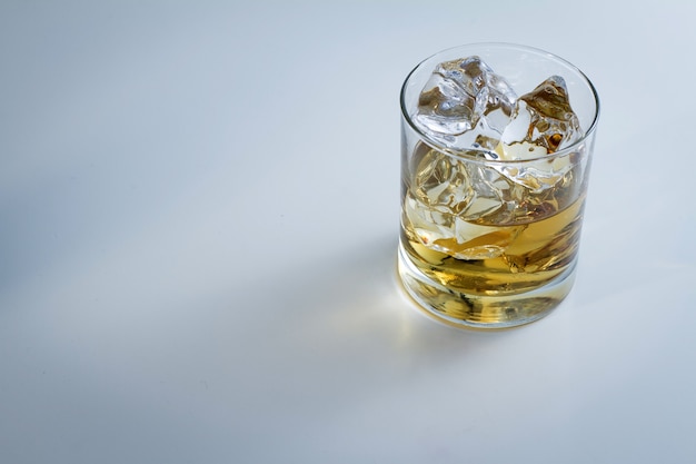 High angle shot of a glass full of ice and some whiskey isolated on a white background