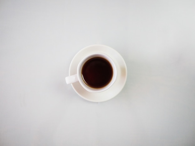 High angle shot of a hot tea in a white cup placed on a white plate