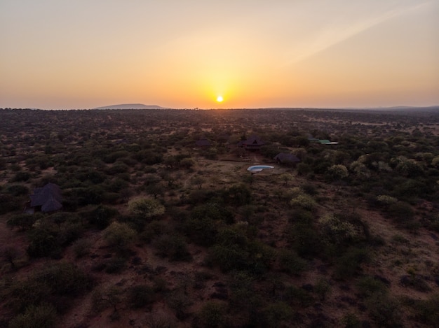 High angle shot of huts among the trees under the beautiful sunset captured in Samburu, Kenya