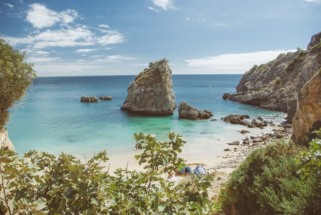 High angle shot of a lot of rock formations near the sea on the beach during daytime