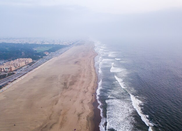 High angle shot of the ocean waves meeting the shore