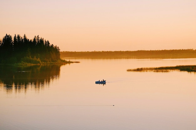 Free Photo high angle shot of people sailing in the boat in the lake during the sunset