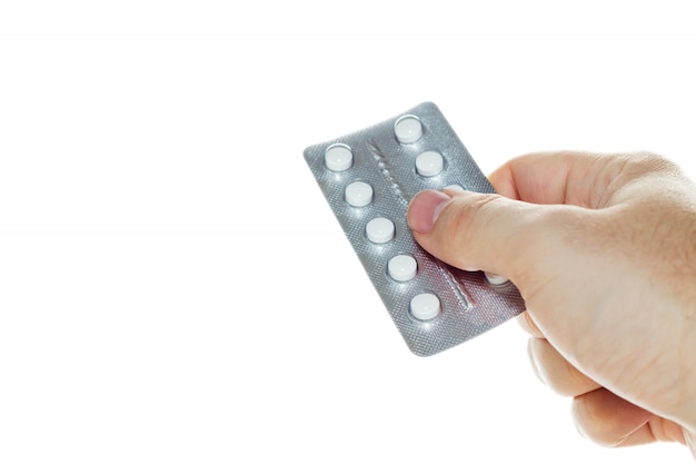 Free Photo high angle shot of a person holding a pack of white pills over a white background