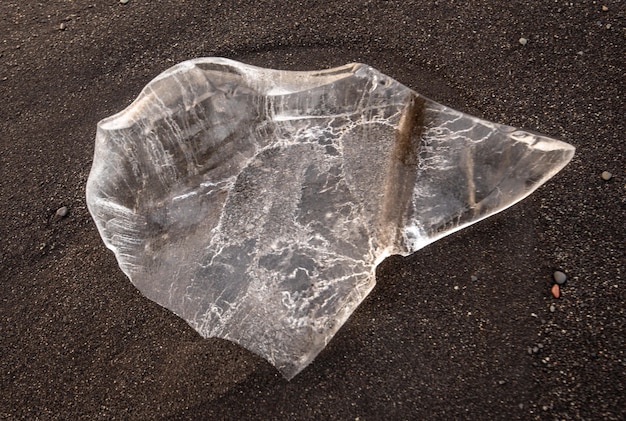 Free photo high angle shot of a transparent crystal stone on the soil