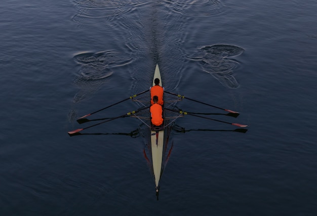 Free Photo high angle shot of two people paddling in a boat in the middle of the sea