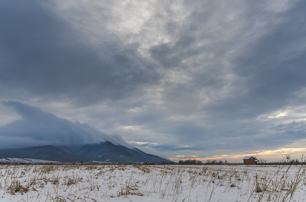 Free photo high angle shot of a valley covered with snow under the dark cloudy sky