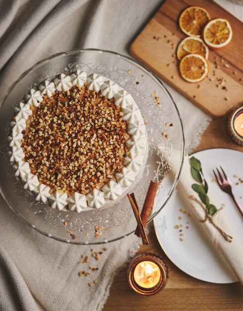 High angle shot of a white delicious Christmas cake with nuts and mandarine