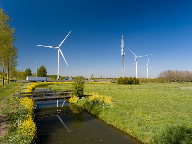 High angle shot of wind turbines near the highways and meadows captured in the Netherlands