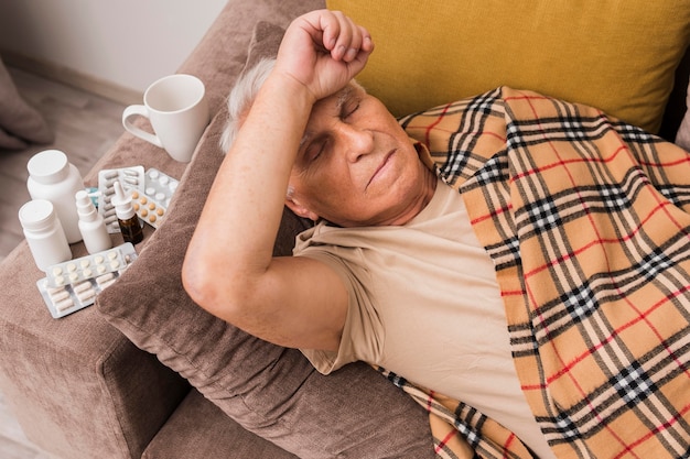 Free Photo high angle sick man laying on couch