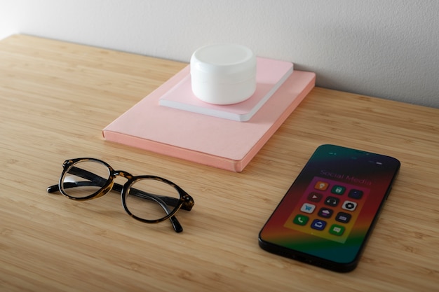 High angle of smartphone on desk with glasses