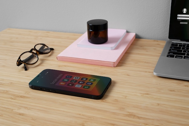 High angle of smartphone on desk with glasses