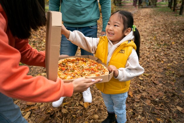 High angle smiley girl holding pizza