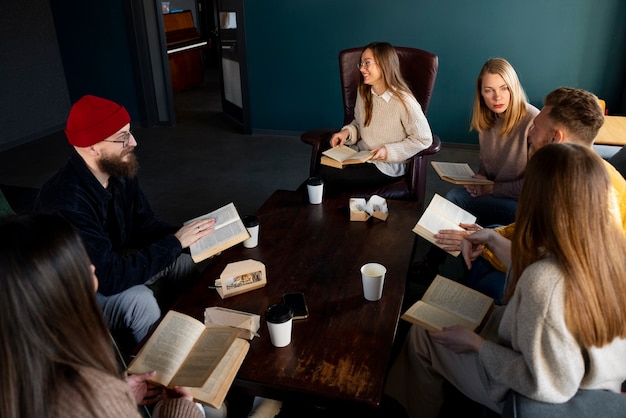 Free photo high angle smiley people at book club