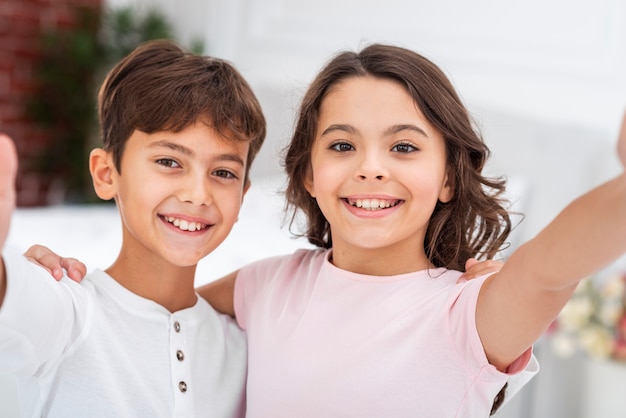 Free photo high angle smiley siblings hugging