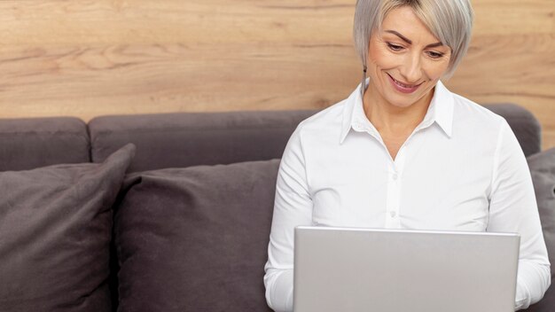 High angle smiley woman working on laptop