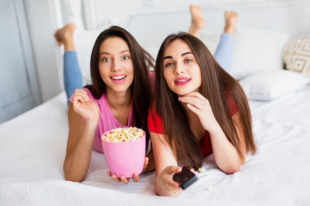 Free Photo high angle smiley women eating popcorn