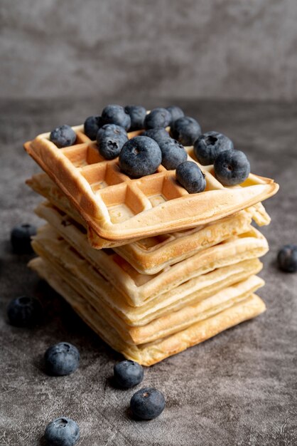 High angle of stacked waffles with blueberries on top