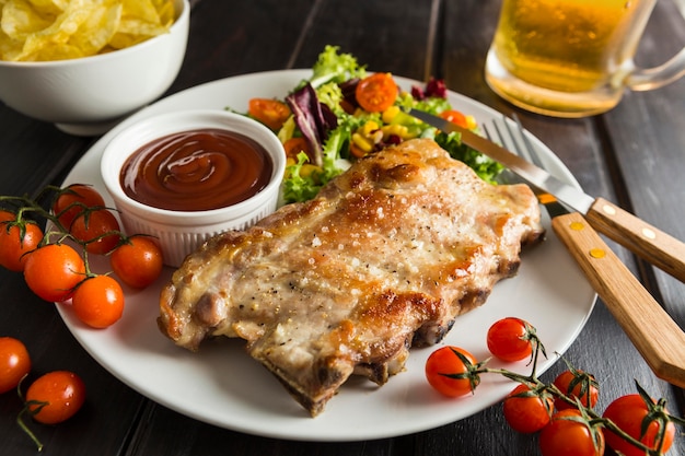 Free Photo high angle of steak on plate with beer and salad