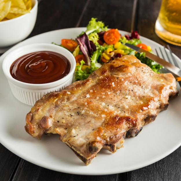 High angle of steak on plate with beer and sauce