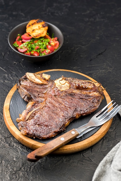 Free Photo high angle of steak with cutlery and salad