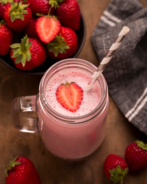 High angle of strawberry milkshake with straw