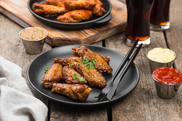 High angle of table with fried chicken on plates and fizzy drinks