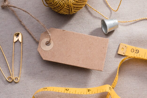 High angle of tag with measuring tape and thimble