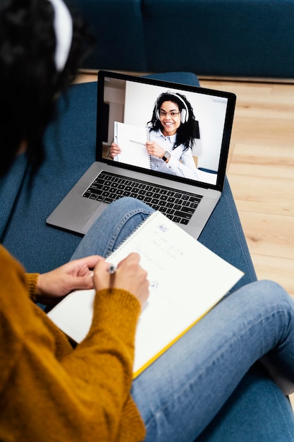 High angle of teenage girl with headphones during online school