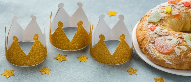 Free photo high angle of three crowns with dessert for epiphany day