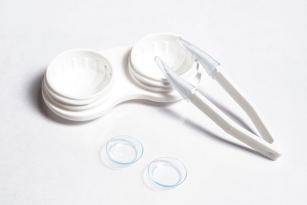 Free Photo high angle of transparent contact lenses with case and tweezers