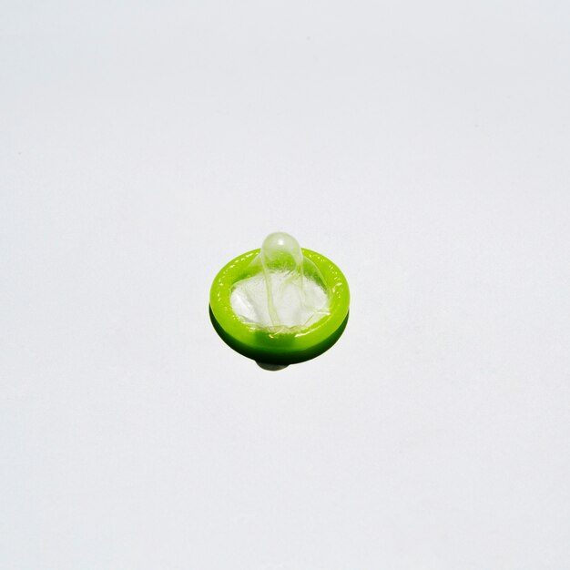 Free Photo high angle unwrapped condom on white background