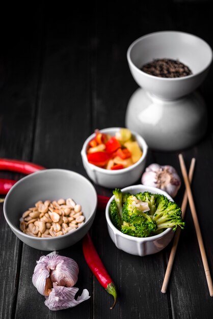 High angle of vegetables in cup with peanuts and garlic