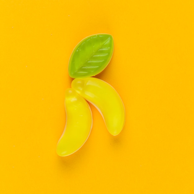 Free Photo high angle view of banana candies on yellow backdrop