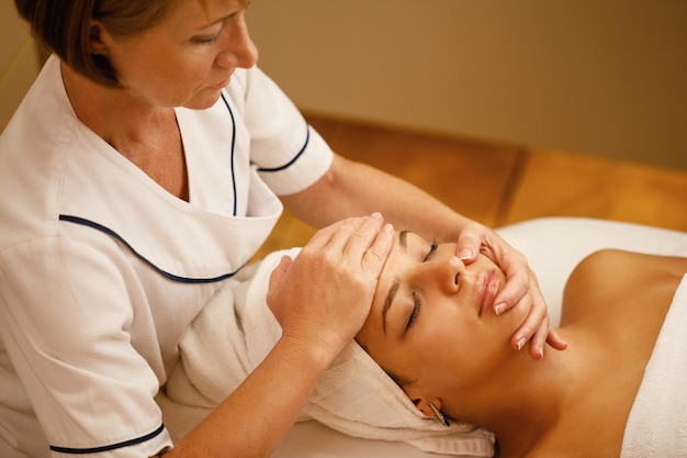 High angle view of beautiful woman having in head massage during beauty treatment at the spa