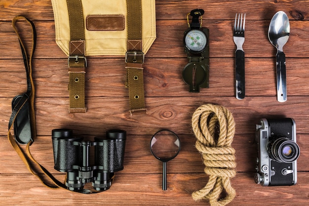 Free photo high angle view of camping equipments on wooden desk