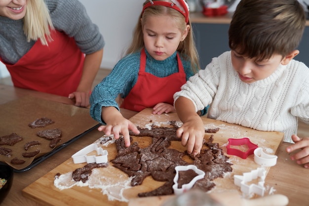 Free Photo high angle view of children cutting out gingerbread cookies