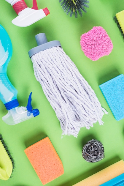 High angle view of cleaning items on green backdrop