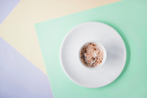 High angle view of coffee on colored backdrop