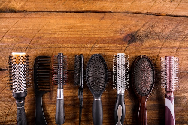 Free photo high angle view of different hairbrushes on wooden backdrop