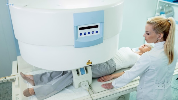 Free photo high angle view of female radiologist and her patient during knee mri scan at clinic