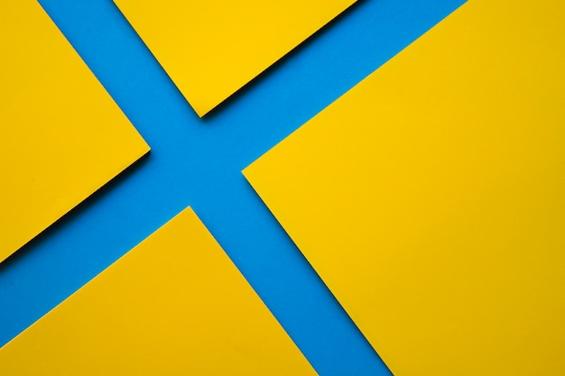 Free photo high angle view of four yellow craft papers on blue surface