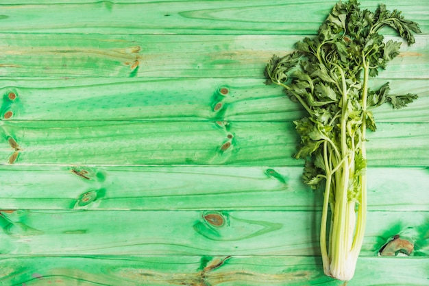 Free photo high angle view of fresh celery on green wooden background