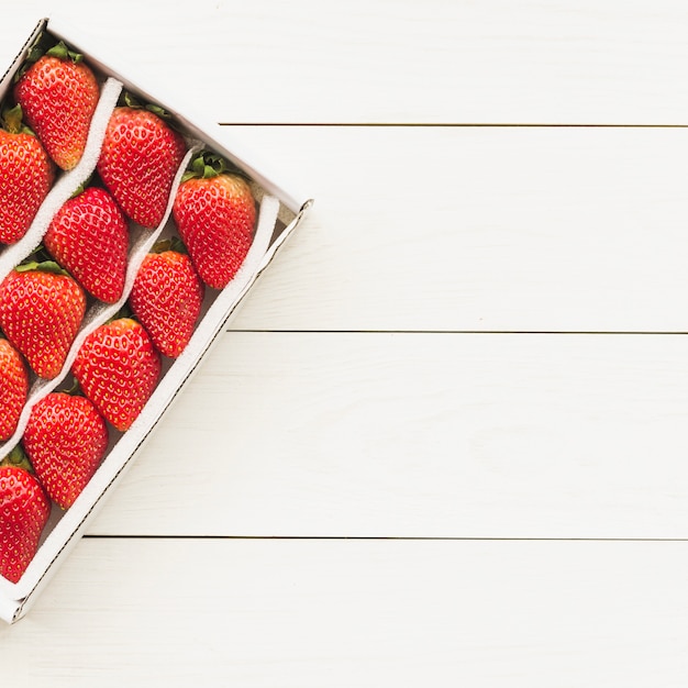 Free photo high angle view of fresh strawberries on wooden background