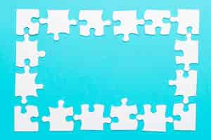 Free photo high angle view of jigsaw puzzle frame on blue backdrop