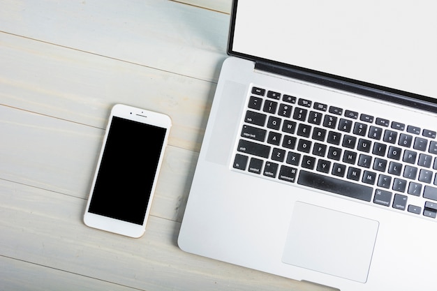 High angle view of laptop and mobile phone on wooden desk