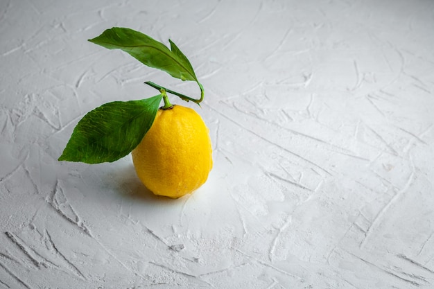 Free photo high angle view lemon with leaves on white textured background. horizontal space for text