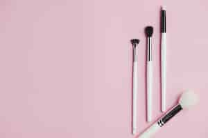 Free photo high angle view of makeup brushes on pink background