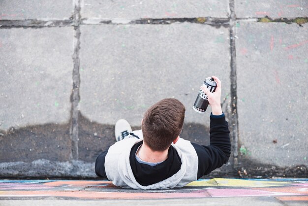 High angle view of man looking at spray bottle