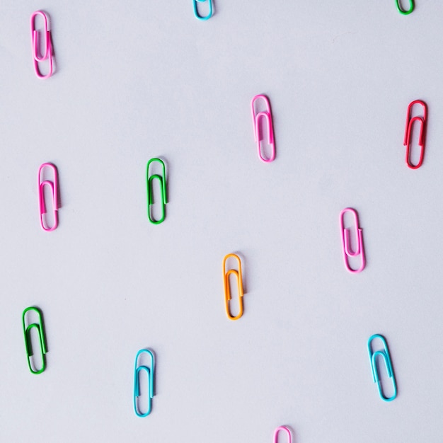 Free Photo high angle view of multi colored paper clips on grey backdrop